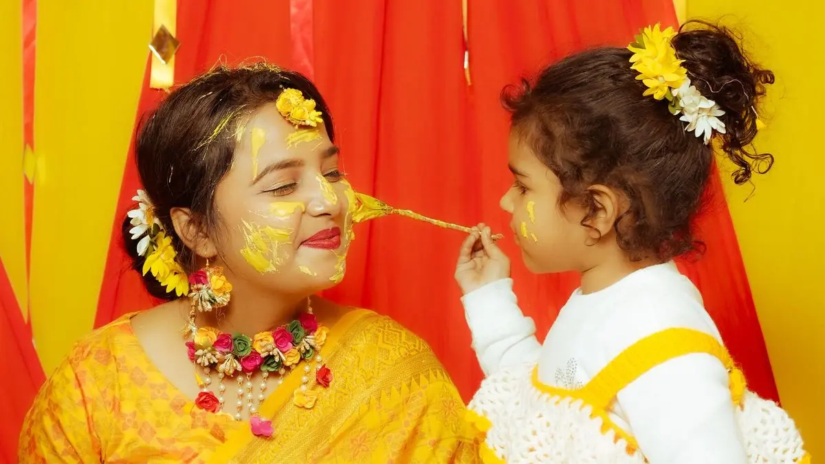Family members applying turmeric paste at a haldi ceremony