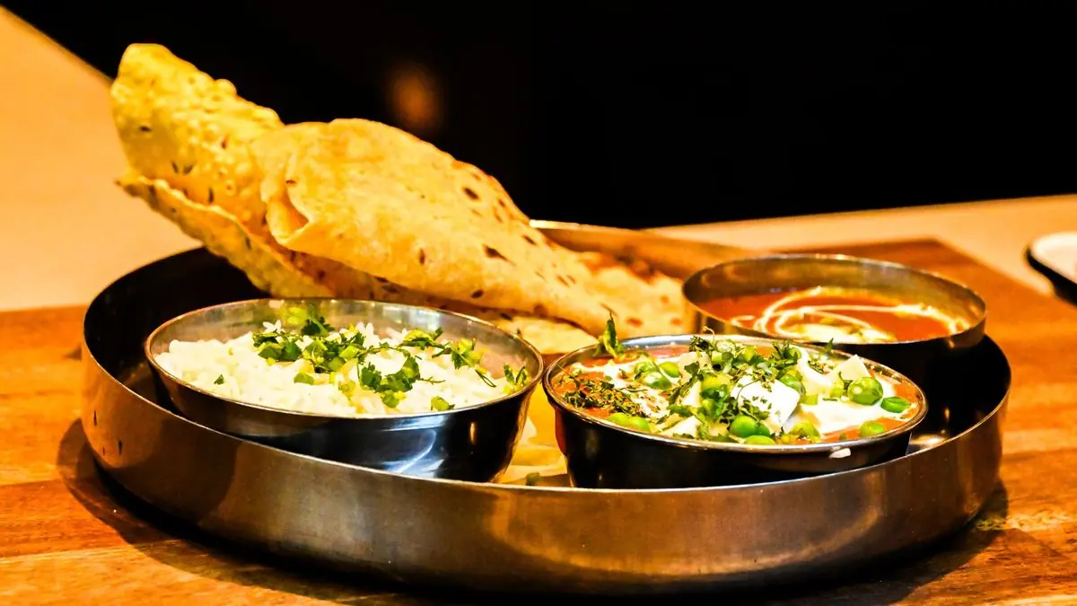 A vegetarian Indian thali with dal, sabzi, rice, roti and sweets