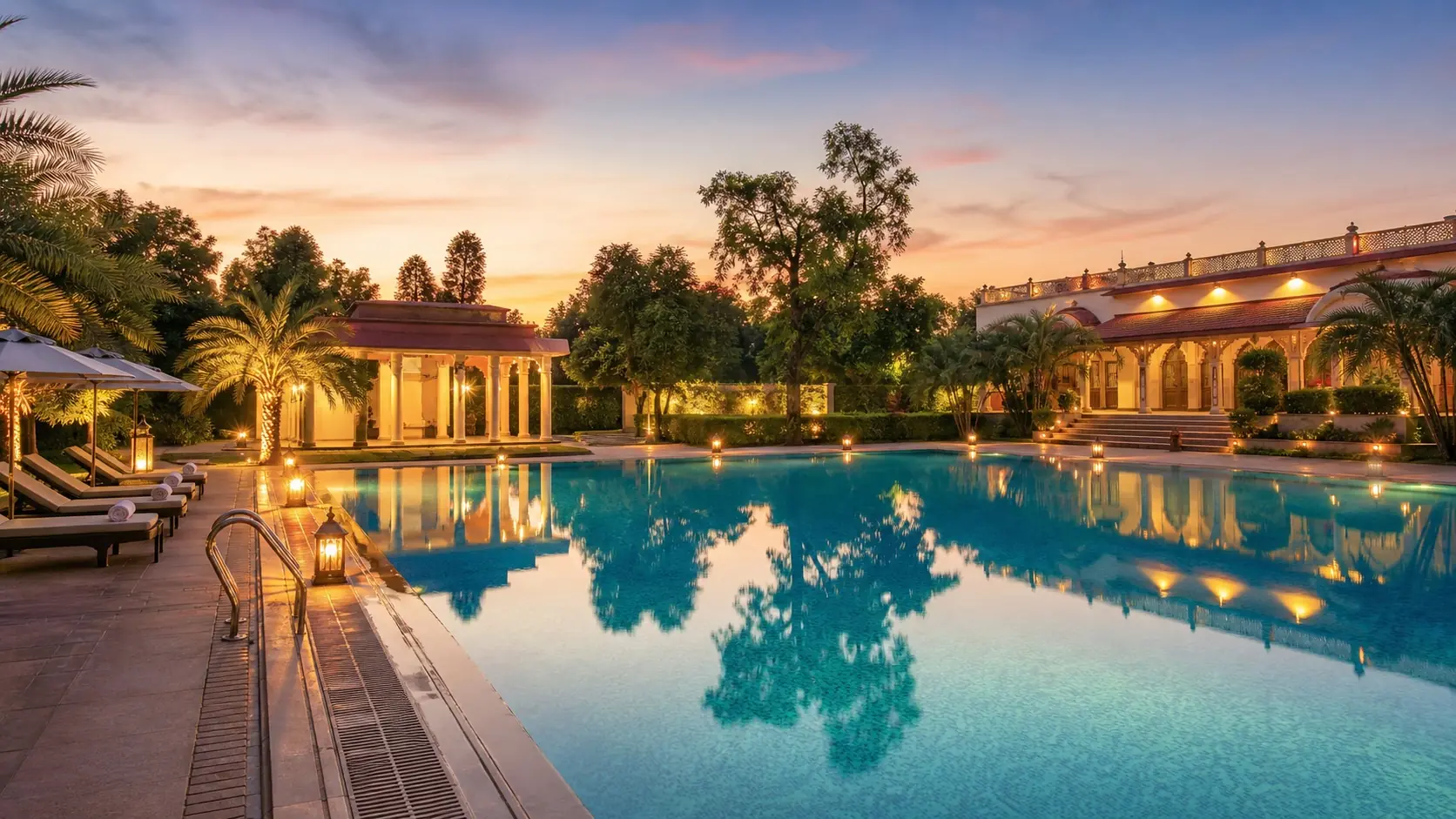 Resort swimming pool at dusk at The Heritage Resort, Misrod Bhopal