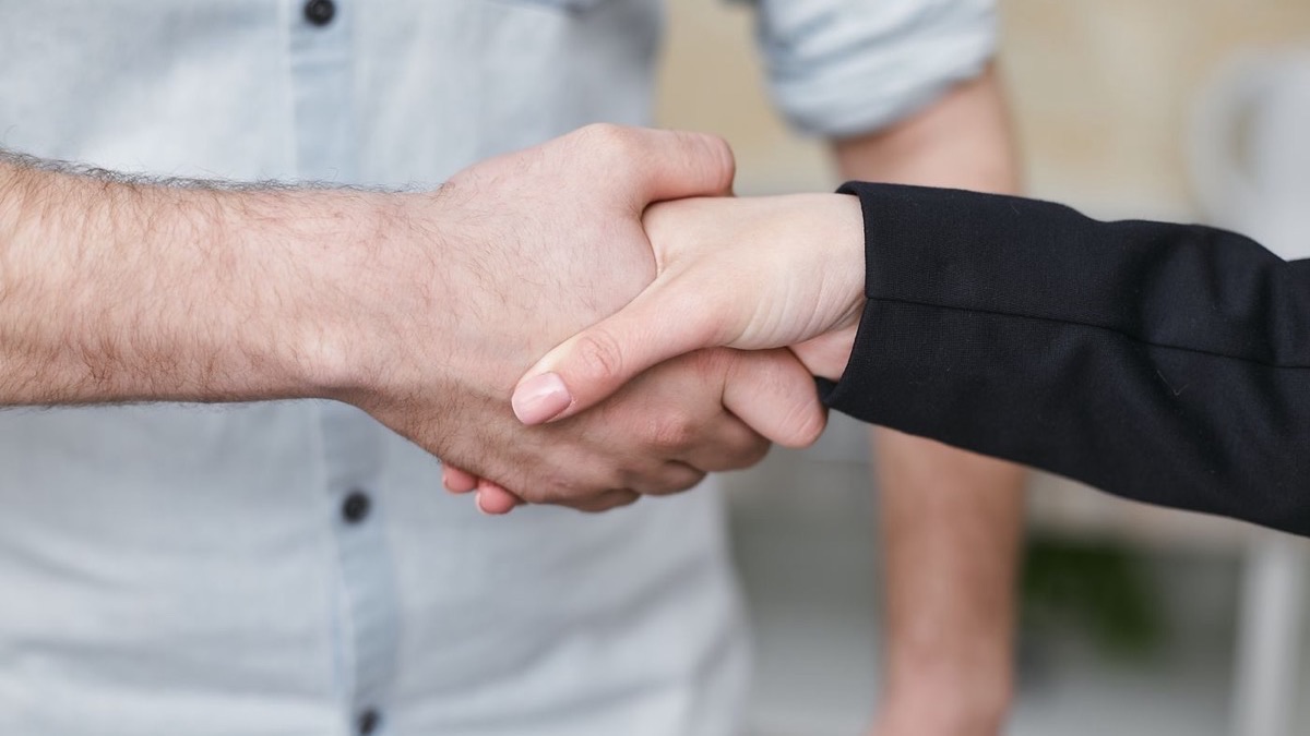 Two people shaking hands to confirm a booking agreement