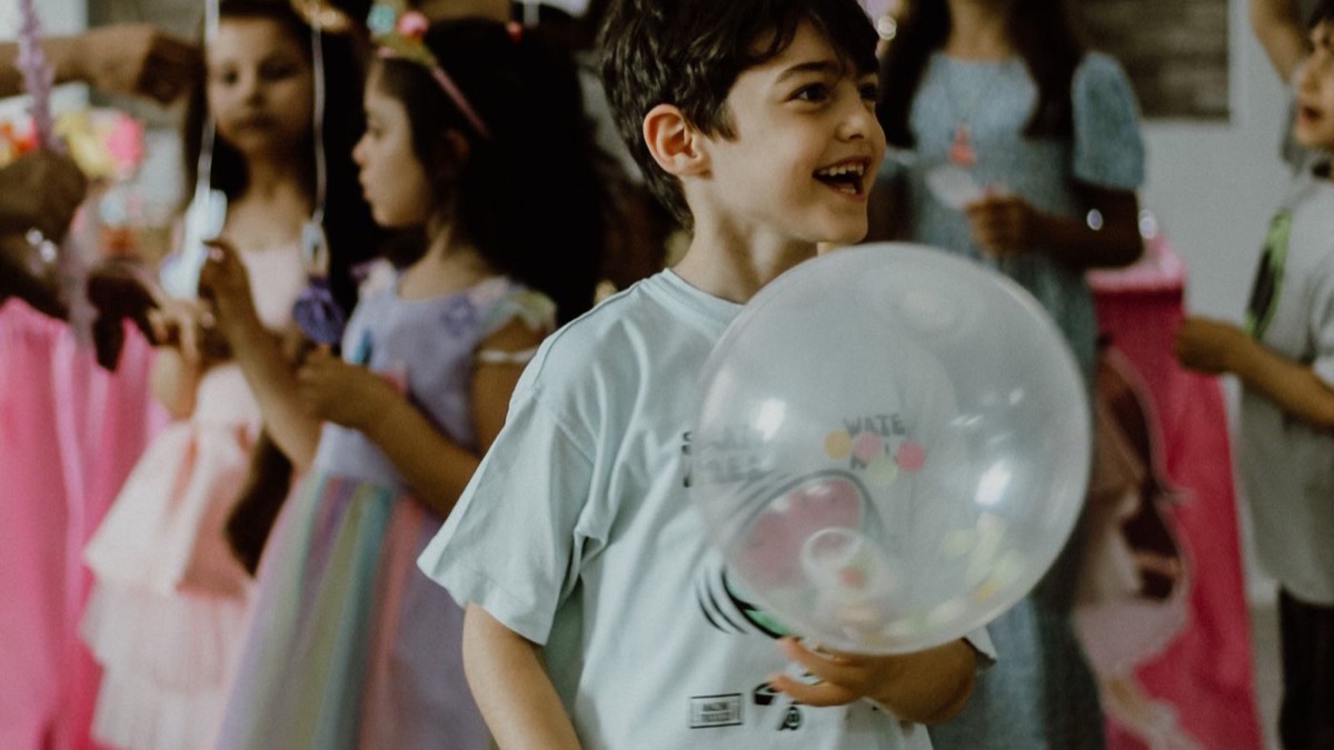 Children celebrating at a birthday party with balloons and decorations